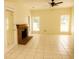 A living room with a brick fireplace, tiled floors, three windows and a ceiling fan at 407 Thomaston Ave, Summerville, SC 29485