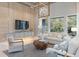 Elegant living room featuring wood accent wall, large windows with backyard view, stylish decor, and ample seating at 4848 Woodville Rd, Awendaw, SC 29429