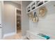 Well-organized mudroom featuring a bench with storage, coat hooks, shelving, and easy access to a pantry at 4848 Woodville Rd, Awendaw, SC 29429