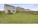 Large backyard featuring grass, a wooden privacy fence, and patio seating with a hammock in the distance at 494 Pender Woods Dr, Summerville, SC 29486