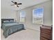 Bedroom with a bed, fan, two large windows with blinds, a dark wood cabinet and carpet flooring at 494 Pender Woods Dr, Summerville, SC 29486