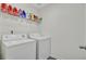 Bright laundry room featuring a white washer and dryer with wire shelving stocked with laundry supplies at 494 Pender Woods Dr, Summerville, SC 29486