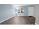 Living room featuring wood-look tile flooring, fresh paint, large window, and staircase to the second floor at 507 Stinson Dr # 4G, Charleston, SC 29407