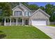 Charming home boasts a welcoming front porch, a well-manicured lawn, and an attached garage at 5105 Parrum Ct, Summerville, SC 29485