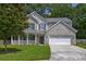 Attractive two-story home with a welcoming covered front porch and well-maintained lawn, perfect for Gathering living at 5105 Parrum Ct, Summerville, SC 29485