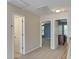 Hallway with neutral walls, carpet, and three doorways leading to various rooms at 5105 Parrum Ct, Summerville, SC 29485
