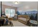 Serene Bedroom featuring a wooden crib, a comfortable glider, and a whimsical forest-themed mural at 5134 E Liberty Park Cir, North Charleston, SC 29405