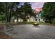 Community area with a fire pit, swing, benches, and well-maintained landscaping between yellow and green homes at dusk at 5134 E Liberty Park Cir, North Charleston, SC 29405