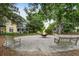 Community area with a fire pit, swing, benches, and well-maintained landscaping between yellow and green homes in the background at 5134 E Liberty Park Cir, North Charleston, SC 29405