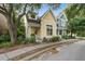Charming two-story home with yellow siding, black door, inviting porch, and lush landscaped yard at 5134 E Liberty Park Cir, North Charleston, SC 29405