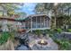 Beautiful backyard featuring a pond, a fire pit, a screened porch, and mature trees for outdoor enjoyment at 520 E Huron Ave, Folly Beach, SC 29439