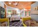 Bright bedroom featuring wood-beam ceilings, ample windows, and two patterned chairs at 520 E Huron Ave, Folly Beach, SC 29439