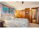 Sunlit bedroom featuring wood paneling, a queen-sized bed, and ensuite closet and bathroom at 520 E Huron Ave, Folly Beach, SC 29439