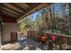 Cozy outdoor deck with wooden railings, seating, and views of lush green foliage at 520 E Huron Ave, Folly Beach, SC 29439