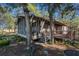 Exterior of property with screened-in porch and trees at 520 E Huron Ave, Folly Beach, SC 29439
