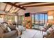 Comfortable living room featuring exposed beam ceiling, wood floors, and sliding doors to outside at 520 E Huron Ave, Folly Beach, SC 29439