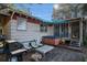 Outdoor patio with a hot tub, grill, seating, and firewood for cozy evenings at 520 E Huron Ave, Folly Beach, SC 29439