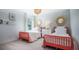Bright bedroom featuring two red twin beds, white nightstand, decor, and a window for natural light at 529 Blue Mistflower Dr, Moncks Corner, SC 29461
