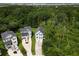 Aerial shot showcasing the home nestled amidst lush woods and a manicured lawn at 542 Amalie Farms Dr, Charleston, SC 29492