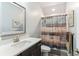 Clean, well-lit bathroom with granite countertops, decorative framed mirror, and shower at 542 Amalie Farms Dr, Charleston, SC 29492