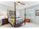 Cozy bedroom with a four-poster bed, ceiling fan, and bright windows at 542 Amalie Farms Dr, Charleston, SC 29492