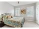 Cozy bedroom featuring a decorative bedspread, two windows with shutters, and neutral walls at 542 Amalie Farms Dr, Charleston, SC 29492