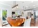 Open dining room with wood table, pendant lighting, and an island in the connected, modern kitchen at 542 Amalie Farms Dr, Charleston, SC 29492