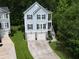 Beautiful two-story home featuring dual garage doors, an elevated porch, and lush greenery at 542 Amalie Farms Dr, Charleston, SC 29492