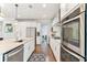 Contemporary white kitchen featuring stainless steel appliances, granite counters, and dark hardwood floors at 542 Amalie Farms Dr, Charleston, SC 29492