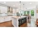 Bright kitchen with white cabinets, a center island with seating, and pendant lighting at 542 Amalie Farms Dr, Charleston, SC 29492