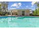 A clear view of the community pool with steps leading down to the spa, and a pool house in the background at 542 Amalie Farms Dr, Charleston, SC 29492