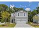 Beautiful two-story home boasting a well-manicured lawn, gray siding, and an attached garage at 551 Blue Mistflower Dr, Moncks Corner, SC 29461