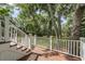 Spacious wooden back deck with white railing offers serene views of the lush, green backyard at 578 Island Walk East, Mount Pleasant, SC 29464