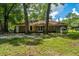 A brick home features a spacious backyard with mature trees and a small playhouse, perfect for outdoor activities at 610 Old Golf Rd, Summerville, SC 29483