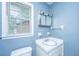 Bathroom with blue walls, window and toilet at 610 Old Golf Rd, Summerville, SC 29483