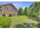Well-maintained backyard with lush green lawn, mature trees, and brick home in the background at 750 Navigators Run, Mount Pleasant, SC 29464