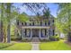 Traditional brick home with black shutters, a covered porch, and mature landscaping at 750 Navigators Run, Mount Pleasant, SC 29464
