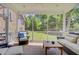 Relaxing screened porch with wicker furniture overlooking lush backyard and beautiful wooded views at 750 Navigators Run, Mount Pleasant, SC 29464