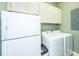 Laundry room featuring a washer, dryer, overhead cabinets, and a refrigerator at 762 Swanson Ave Ave, Charleston, SC 29412