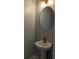 Elegant powder room with a bronze faucet, pedestal sink, decorative mirror and lighting fixture at 7763 Park Gate Dr, North Charleston, SC 29418