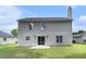 A view of the rear of the house with a concrete patio and grassy backyard at 8044 Old London Rd, North Charleston, SC 29406