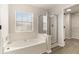 Bright bathroom featuring a garden tub, shower, window and a door to a large walk-in closet at 8044 Old London Rd, North Charleston, SC 29406