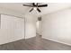 A view of an empty bedroom with closet and doorway, gray hardwood flooring, and a ceiling fan at 8044 Old London Rd, North Charleston, SC 29406