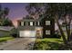 Charming two-story home with a two-car garage and a well-manicured front yard at dusk at 8044 Old London Rd, North Charleston, SC 29406