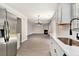 Bright kitchen with white cabinetry and stainless steel appliances, with an open view to the living room at 8044 Old London Rd, North Charleston, SC 29406