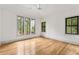 Bright bedroom with hardwood floors, a ceiling fan, and large windows overlooking the backyard at 8187 Jack Island Dr, Johns Island, SC 29455