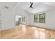 Bright bedroom featuring light wood floors, a ceiling fan, and large windows with wooded views at 8187 Jack Island Dr, Johns Island, SC 29455
