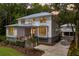 Charming two-story coastal home with a metal roof, wooden staircase, lush landscaping, and a detached garage at 8187 Jack Island Dr, Johns Island, SC 29455