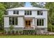 Charming two-story home with a bright white exterior, metal roof, and a welcoming front porch and landscaped front yard at 8187 Jack Island Dr, Johns Island, SC 29455
