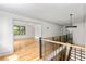 Bright hallway with hardwood floors, decorative lighting, and large windows at 8187 Jack Island Dr, Johns Island, SC 29455
